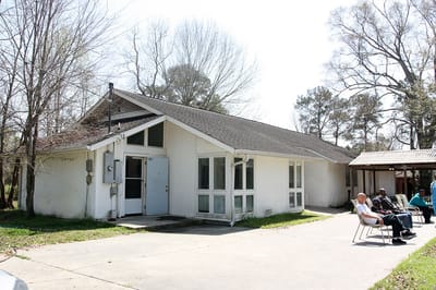 Building exterior with residents sitting outside