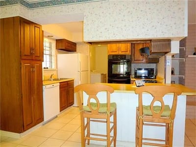 Bright kitchen area with wooden cabinets and appliances