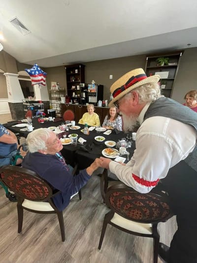 Residents enjoying a meal and entertainment in the dining room