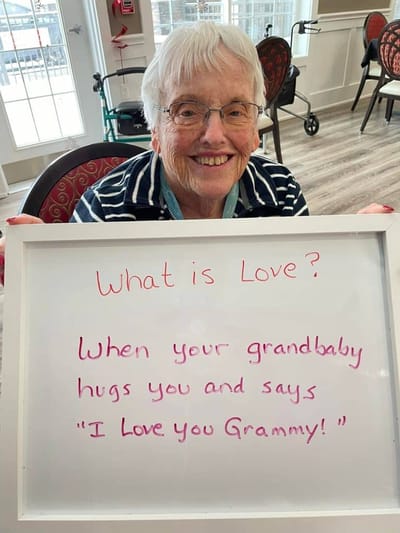Resident holding a whiteboard with a heartfelt message