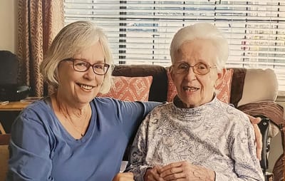 A caregiver and resident smiling together