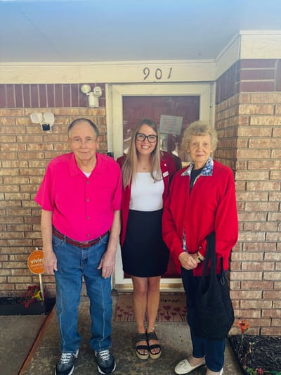 A staff member with two residents at the entrance
