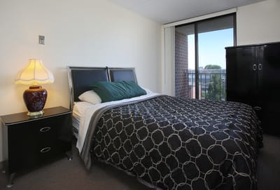 Cozy, well-lit private bedroom in assisted living facility