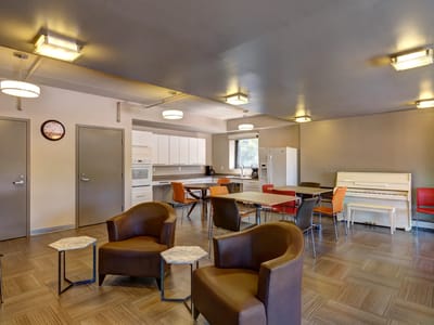 Bright common area with seating and piano