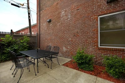 Outdoor patio space with seating and greenery