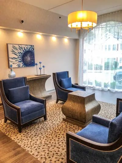A cozy common area with blue chairs and a coffee table