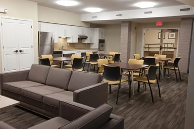 Common area with seating and dining tables in a senior facility