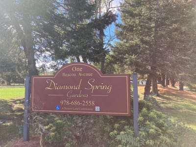 Sign for Diamond Spring Gardens outside in a green space