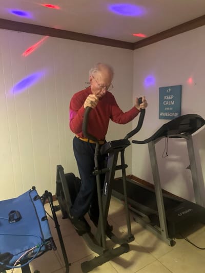 Senior man exercising on an elliptical machine indoors
