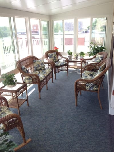 Bright sunroom with wicker chairs and plants