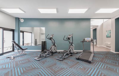 Fitness room with exercise equipment and large windows