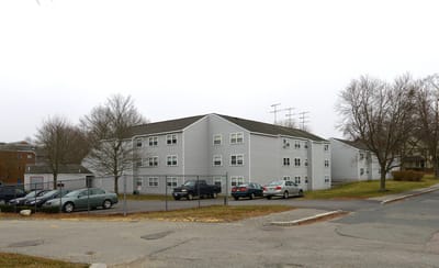 Exterior view of a senior living building with parking