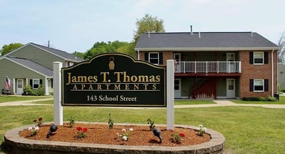Exterior view of James T. Thomas Apartments building and sign