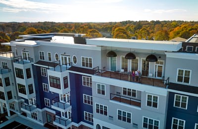Aerial view of a modern assisted living facility with residents on the balcony
