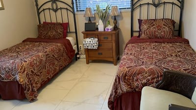 A shared resident room with two beds and decorative bedding.