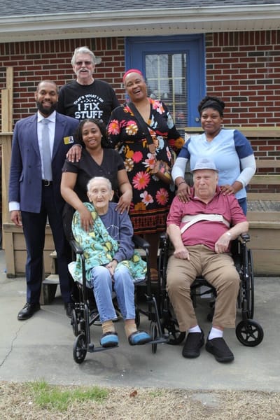 Staff and residents posing together outside