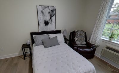 Cozy resident bedroom with a chair and artwork