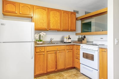 Bright kitchen area with wooden cabinets and appliances
