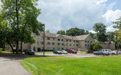 Exterior view of a senior living facility with parked cars