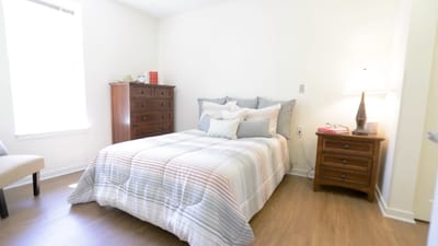 A well-furnished resident bedroom with warm lighting