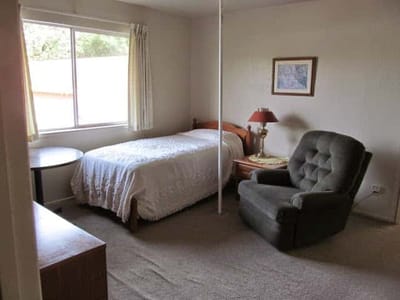 Cozy private resident room with a bed and chair