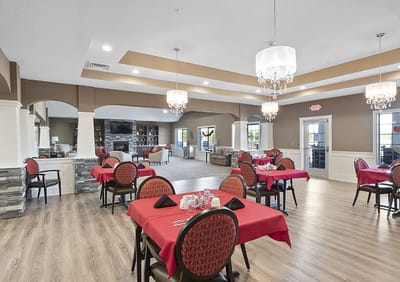 Elegant dining room setup with red tablecloths and chandeliers