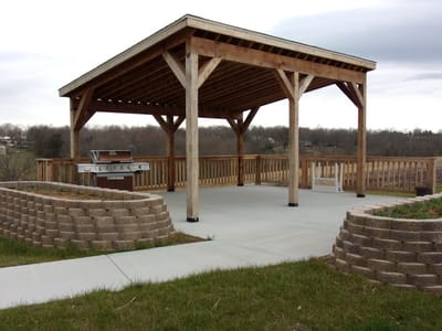 Outdoor shelter with a grill in a landscaped area