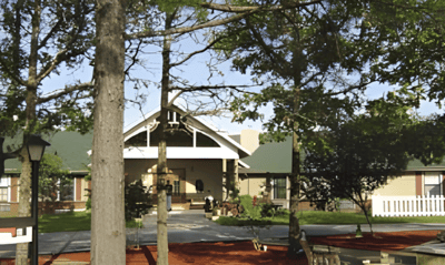 Exterior view of Holly House facility nestled among trees