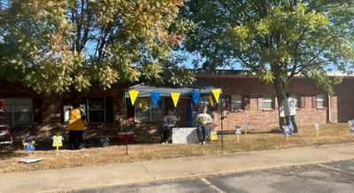 Residents and staff engaging in activities under a tent outside