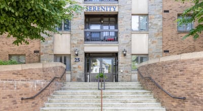 Exterior view of Serenity Towers entrance with stone steps