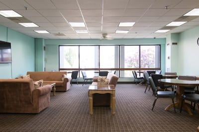 Bright common area with comfortable seating and dining tables