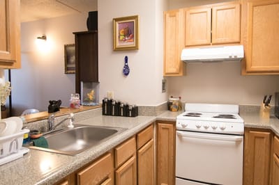 Bright kitchen area with wooden cabinets and appliances