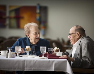 Two residents enjoying dessert in a dining area