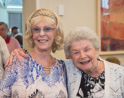 Two residents smiling together in a common area