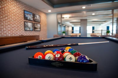 A pool table in a recreational area with colorful balls