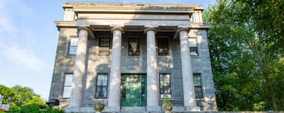 Facade of Grinnell Mansion with columns and green door