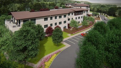 Exterior view of a senior living facility surrounded by trees and landscaping