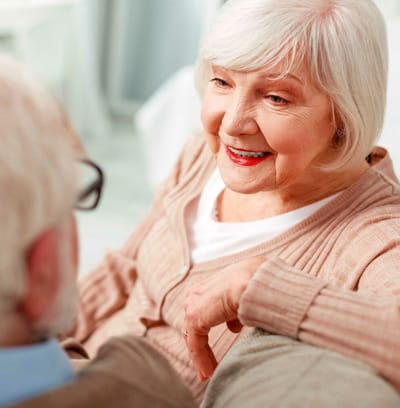 An older woman smiling while engaging in conversation