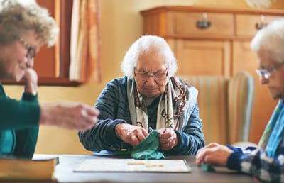 Jenkin`s Living Center, Nursing Home in Watertown, SD — Seniors engaged in a game around a table