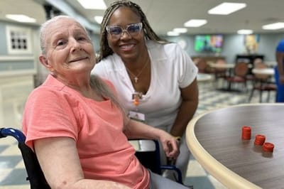 Resident and staff member smiling in a common area