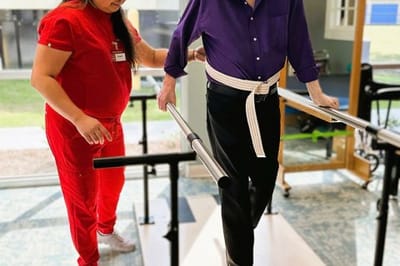 Staff assisting resident during rehabilitation exercise
