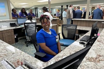 Staff member at the reception desk in a busy common area