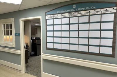 Activity schedule board in a nursing home corridor