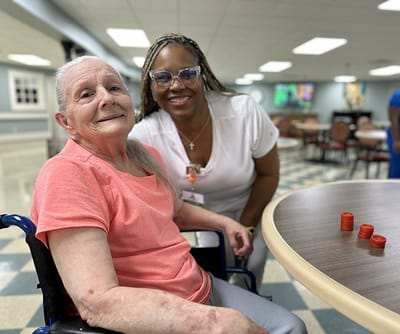Resident and staff member smiling in a common area