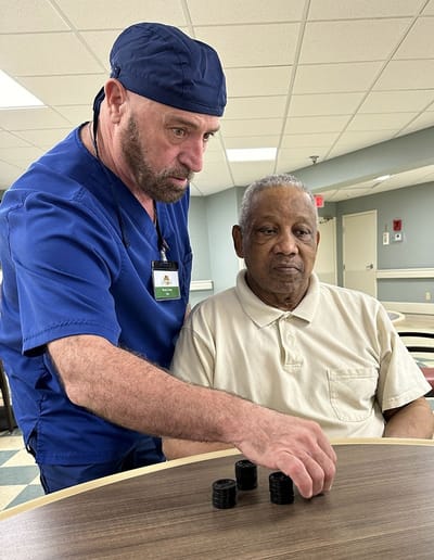 Staff engaging with resident in an activity room