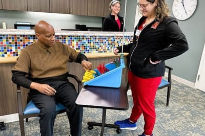 Resident engaging in an activity with staff member