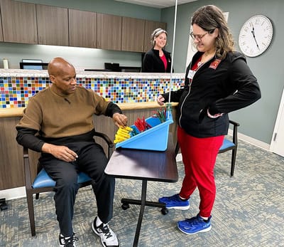 Resident engaged in an activity with staff assistance