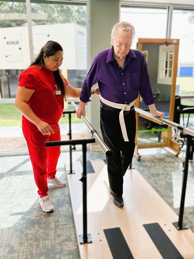 Staff assisting a resident during rehabilitation therapy