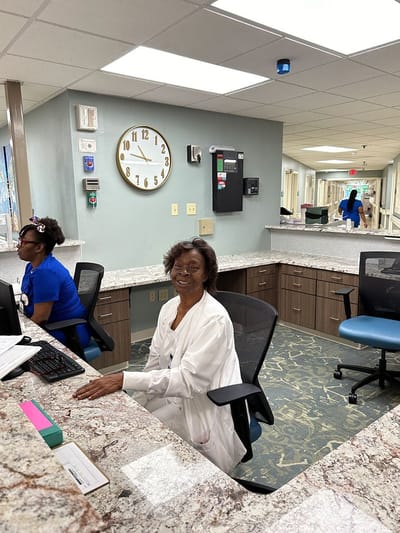 Staff member seated at the reception desk in the facility