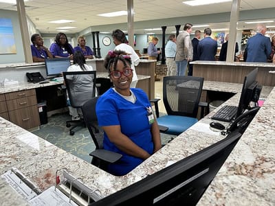 Staff member at the reception desk in a busy common area